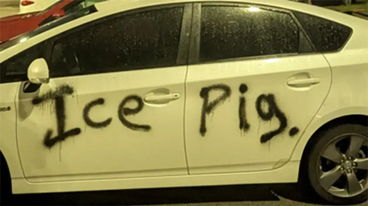 DHS vehicle spray painted with black paint that says “ICE Pig."