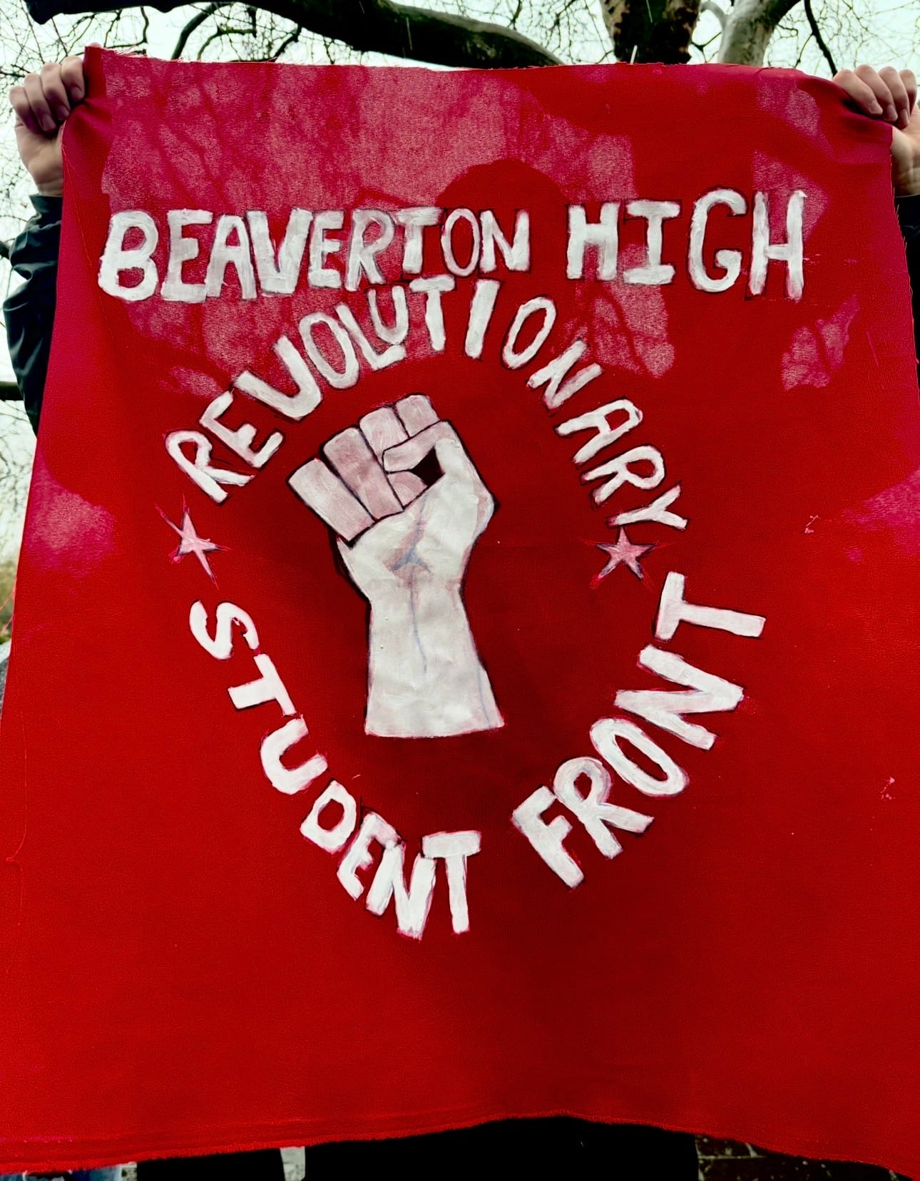 Student holding up a banner that says Beaverton High Revolutionary Student Front