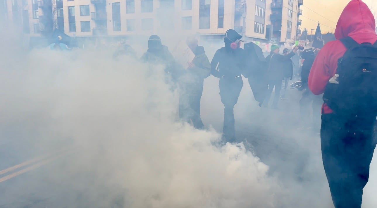 Protesters standing in front of the ICE facility caught in a cloud of teargas
